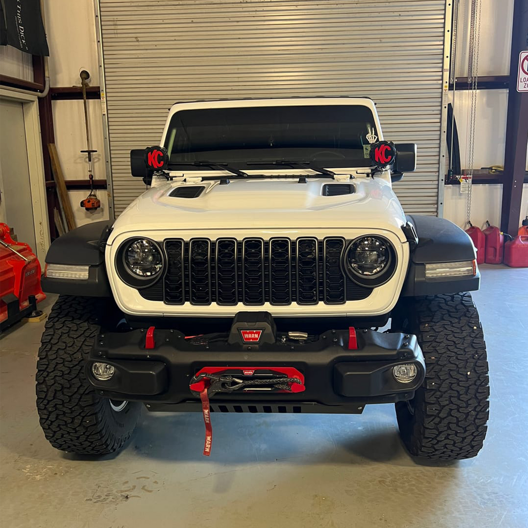 Bright White Jeep with black grille and trim accents in a garage setting