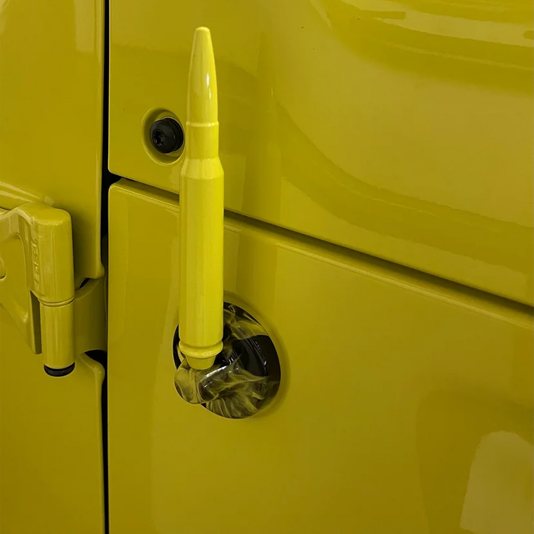 A high velocity yellow 50 caliber solid aluminum bullet antenna attached to a Jeep Wrangler with naughty fire graphic pattern antenna cap