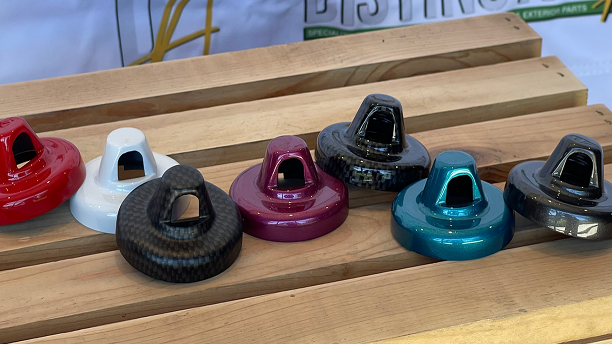 seven antenna caps in different colors on wood box 