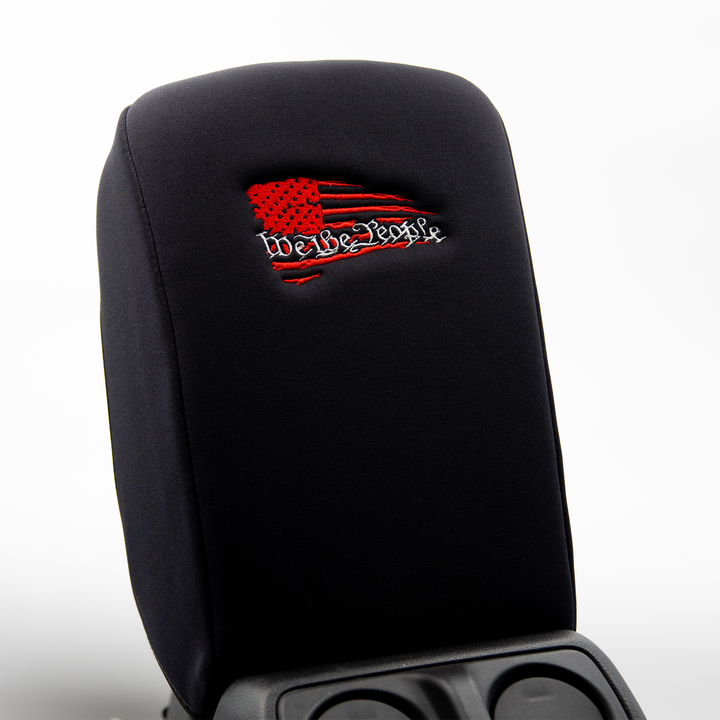 Black console cover with a red and black embroidered flag owith white we the people text over the flag