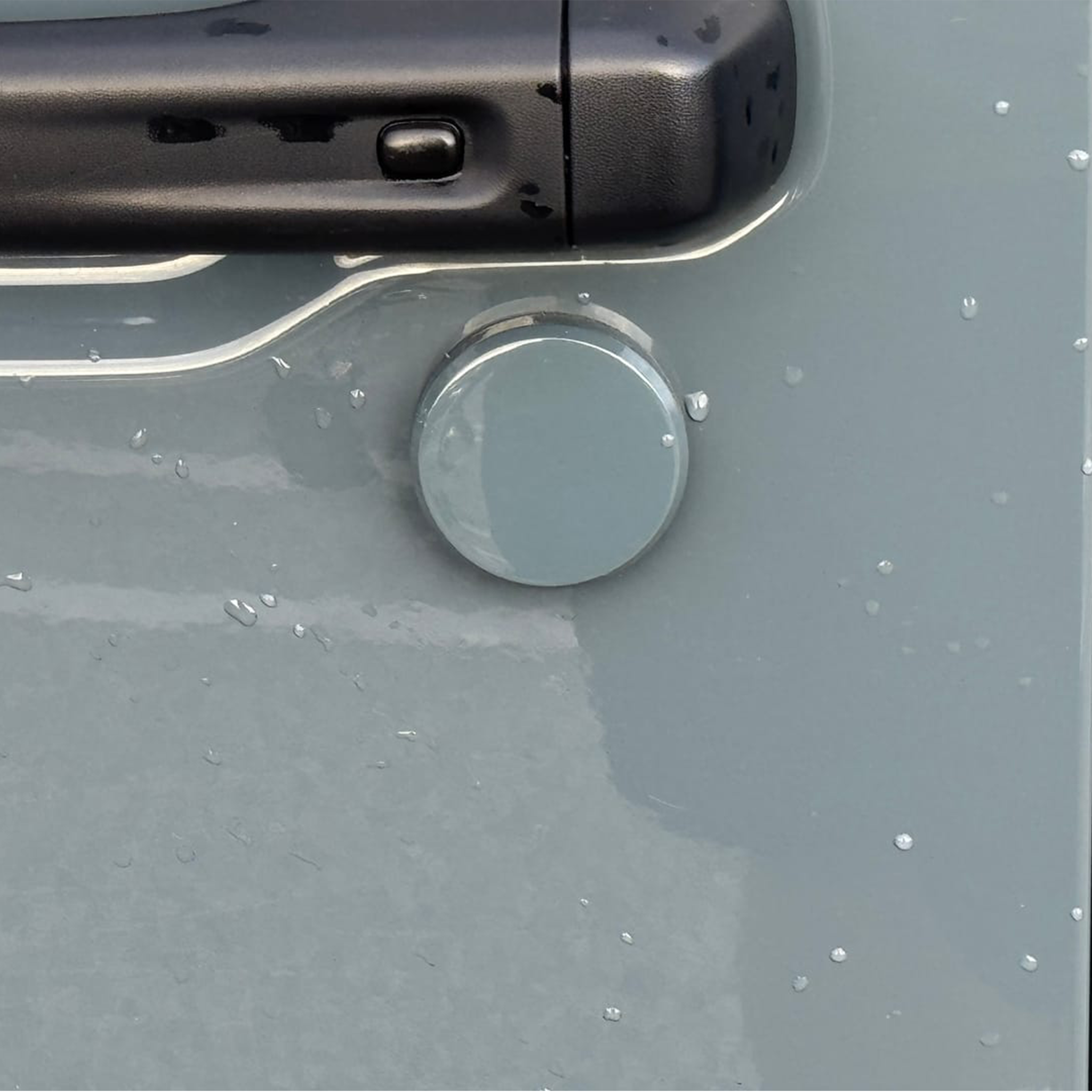 Close-up of a painted cover'd-up keyhole cover in Anvil on a Jeep Wrangler 