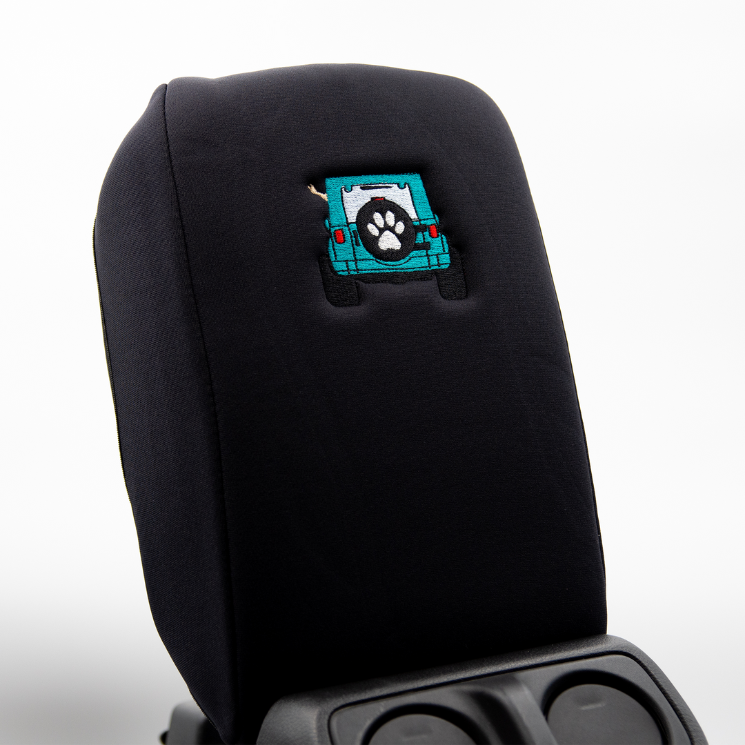 Black console cover with teal color-matched Jeep rear end and black tire cover with white paw print 