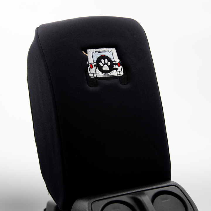 Black console cover with white color-matched Jeep rear end and black tire cover with white paw print 
