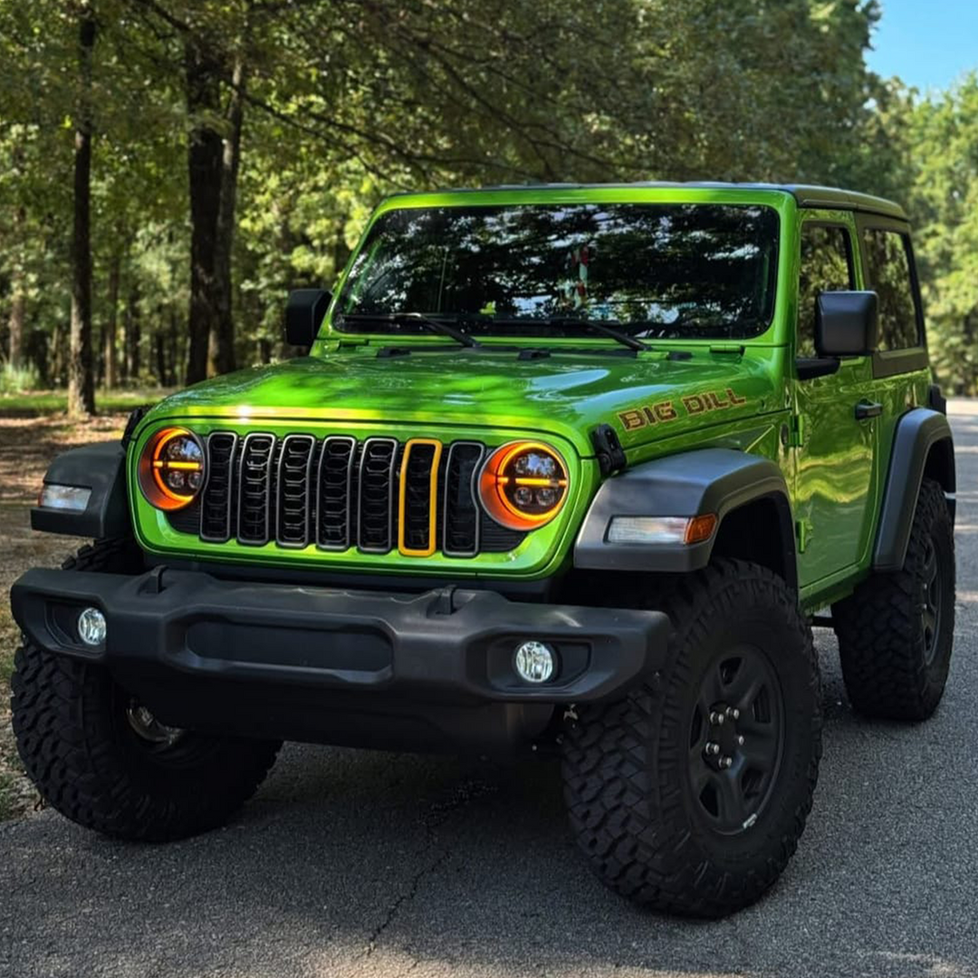 Green Jeep Wrangler parked on a road with Hella Yella Aftermarket stick-on-slot grille trim painted by Distinction Applied