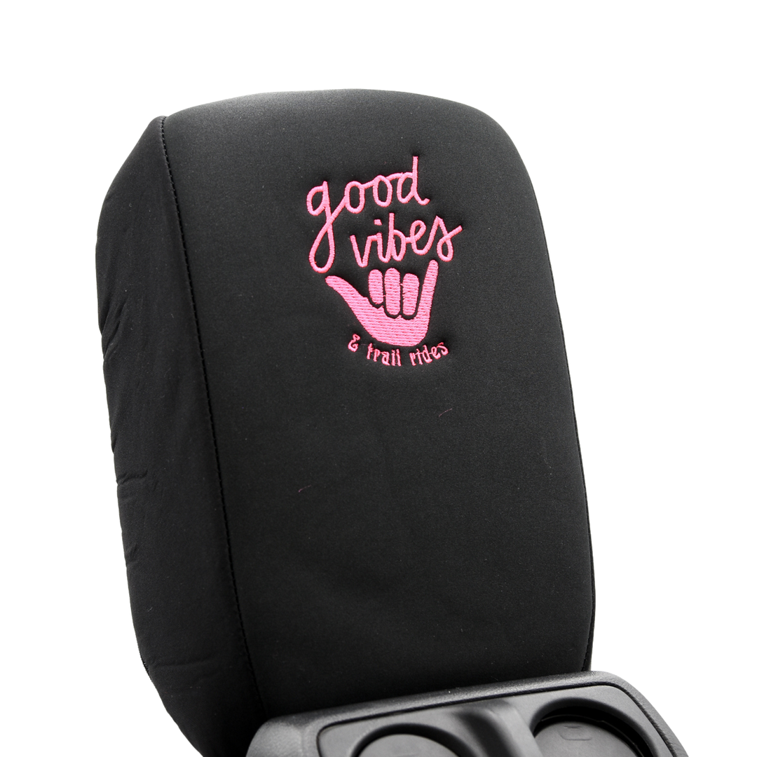 Black console cover with pink 'good vibes' and hand gesture design on a white background