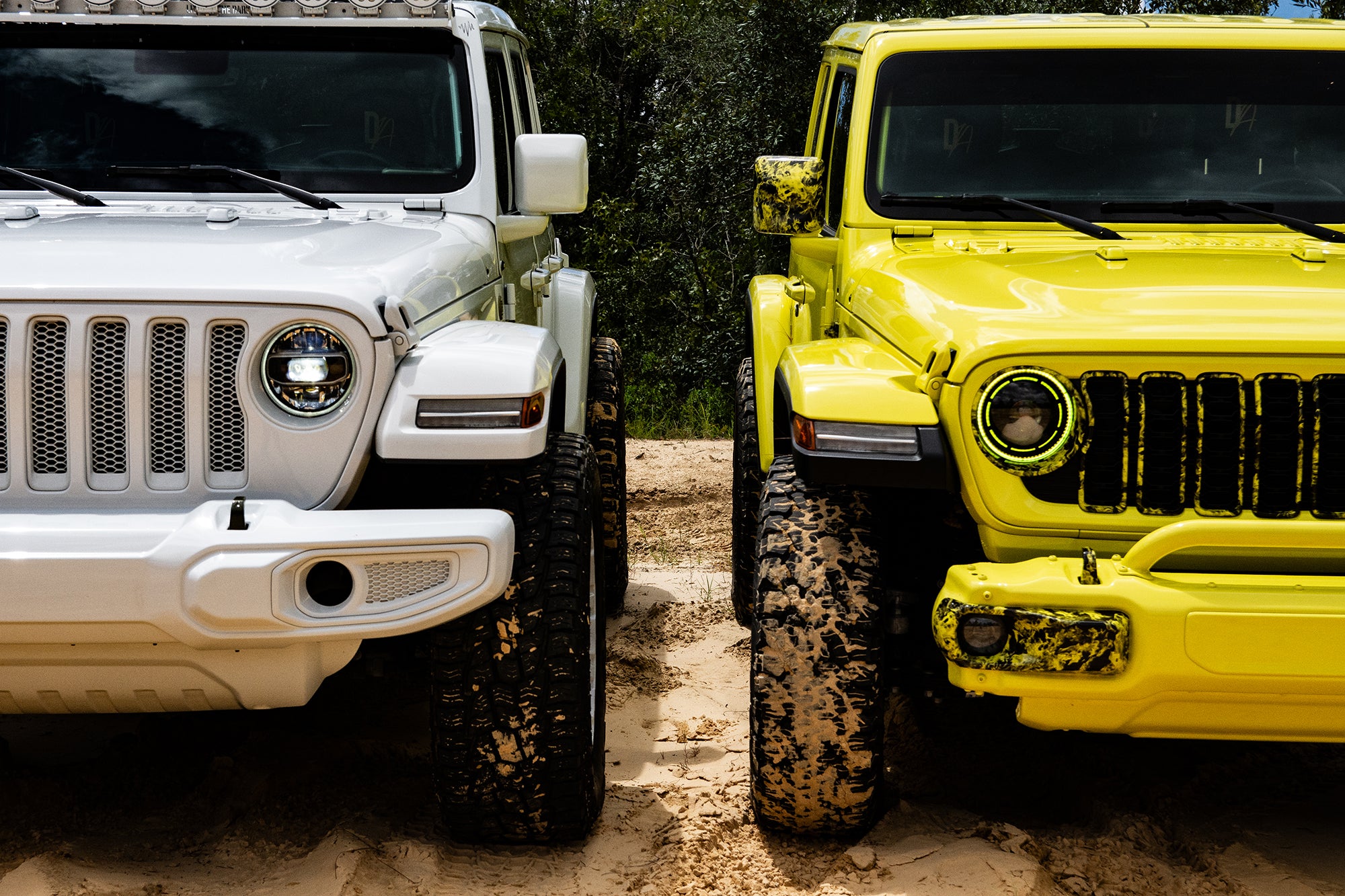 Bright White Jeep JLU and High Velocity Yellow Wrangler JL side-by-side on sand dunes 