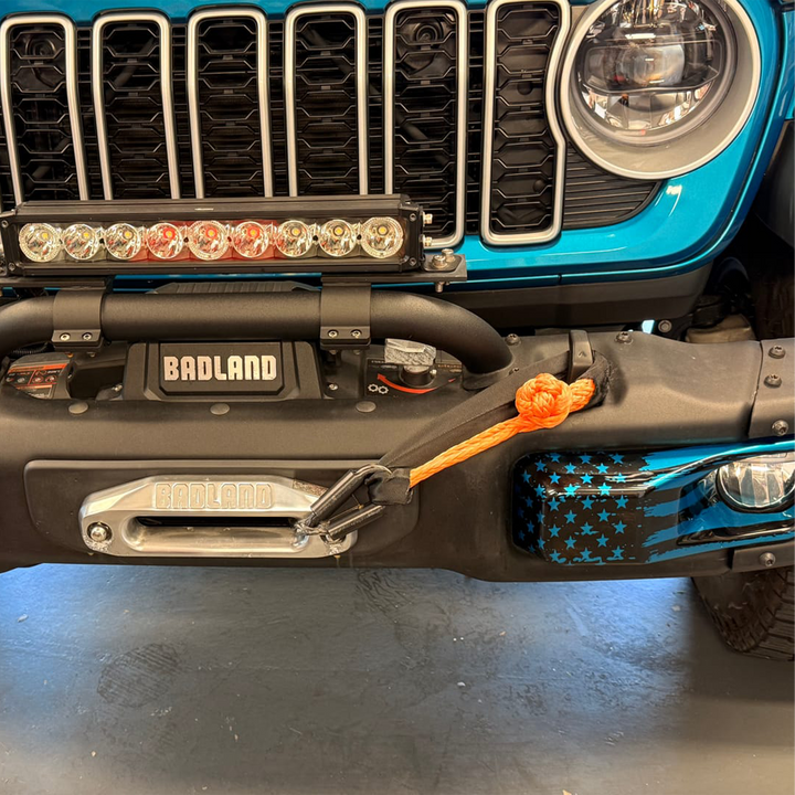 Front view of a Jeep Wrangler steel front bumper fog trim in OEM Bikini Pearl with tattered flag graphic painted and dipped by Distinction Applied.