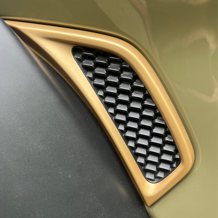 Close-up of a Jeep fender vent with 392 gold trim and black honeycomb pattern.